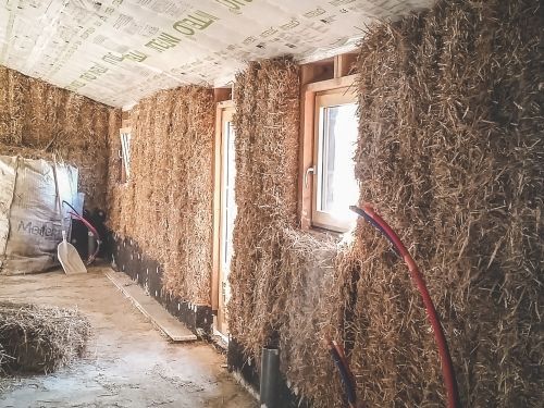 Des bottes de paille entre des bouts de bois