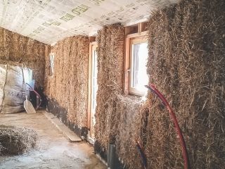 Des bottes de paille entre des bouts de bois