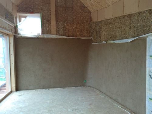 Corps d'enduits terre crue projetté sur bottes de paille