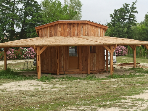 Ombrière de 120m² type halle autour d'une cabane Bois