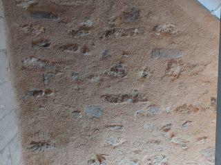 Rejointoiement à la chaux d'un mur enduit au ciment dans une cage d'escalier