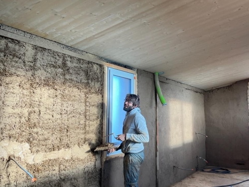 Enduit terre crue sur maison bois-paille