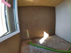Enduit terre crue sur maison bois-paille