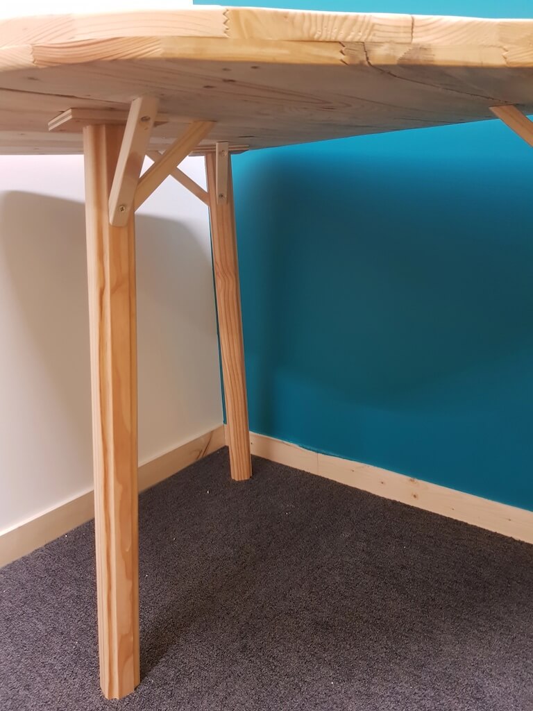 Vue de dessous d'une petite table en bois fabriquée en réemploi