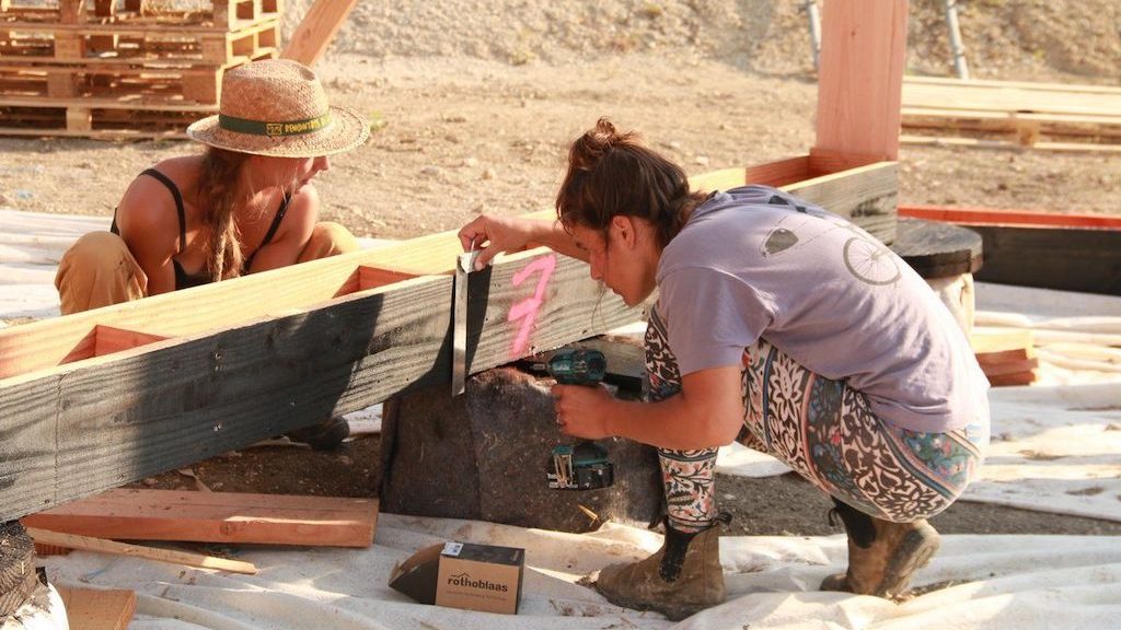 Deux jeunes femmes qui aident à la construction sur un chantier participatif